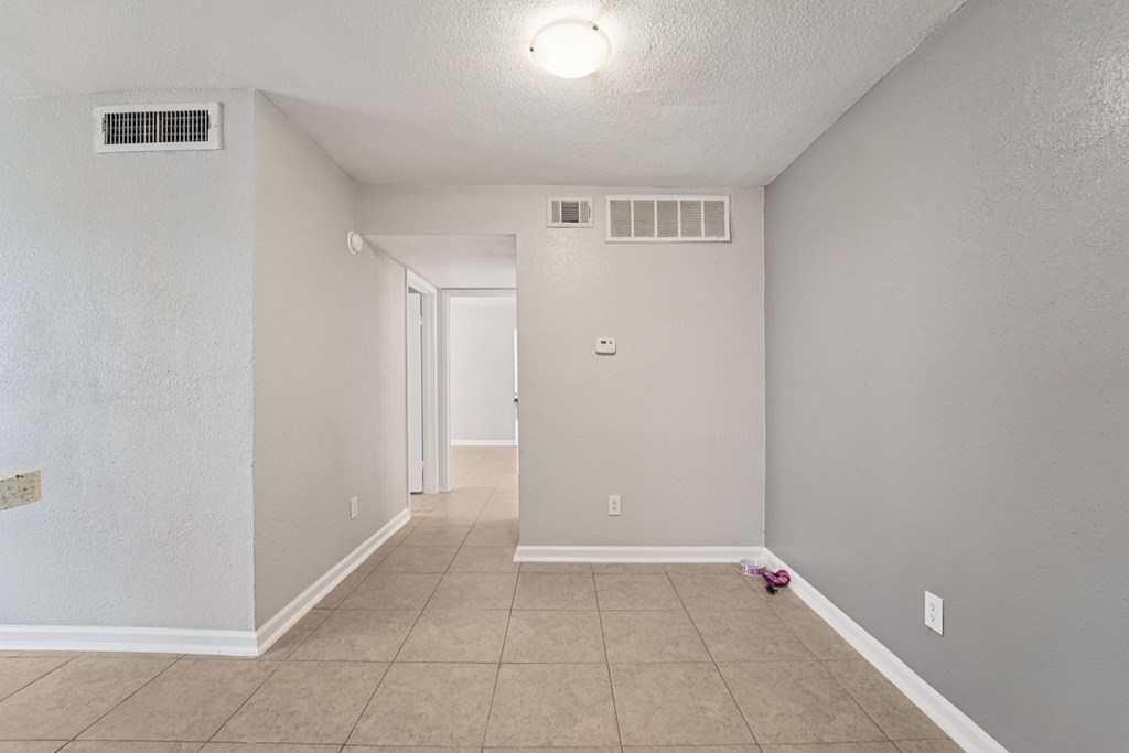 A room with a tiled floor and a doorway leading to another room.