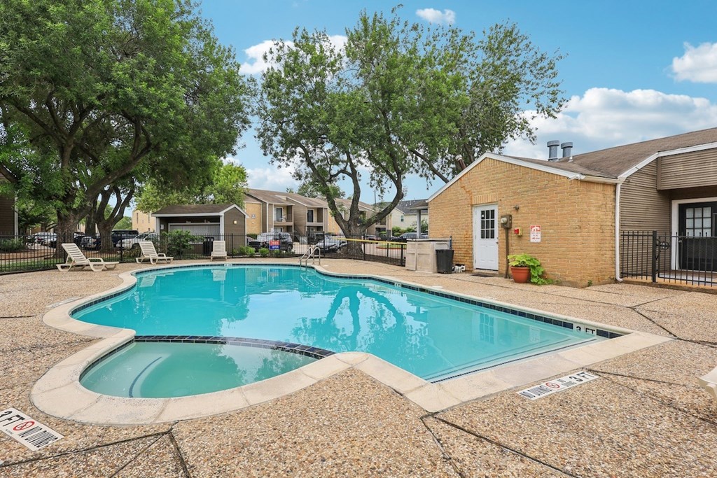 A small pool surrounded by a stone patio.