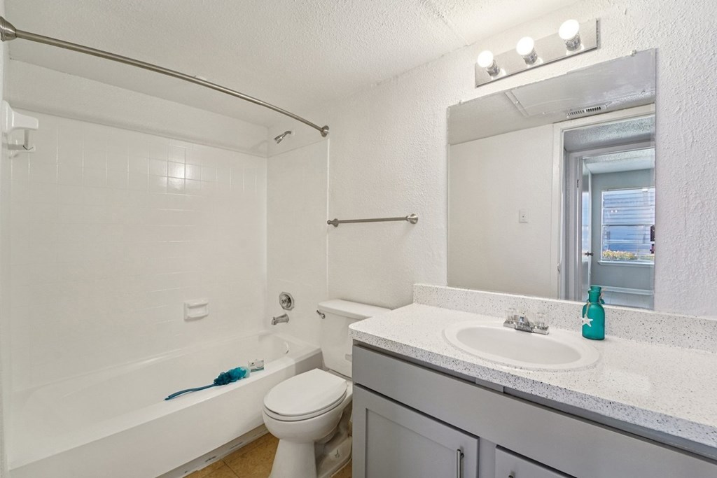 A white bathroom with a toilet, sink, and bathtub.