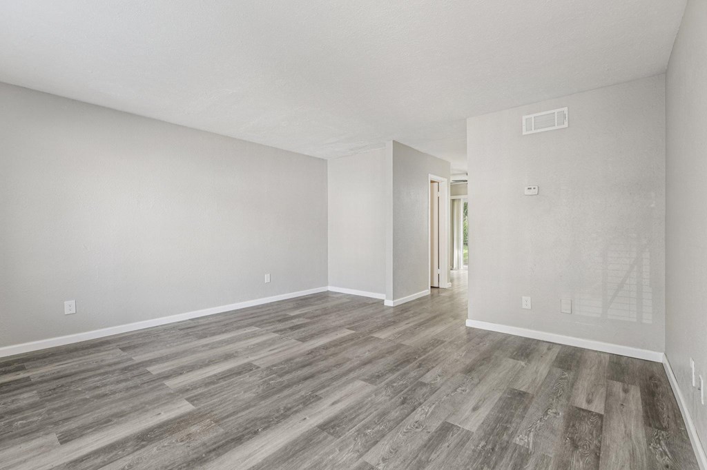 A room with wooden flooring and white walls.