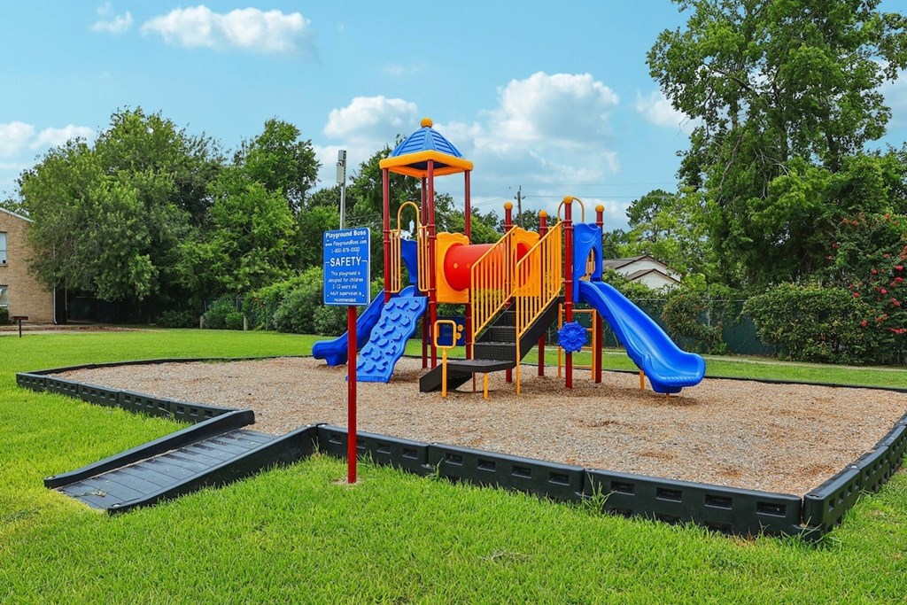 A playground with a blue slide and a yellow slide.