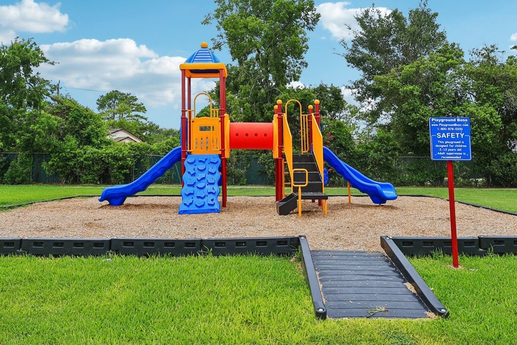 A playground with a blue slide and a yellow and red tower.