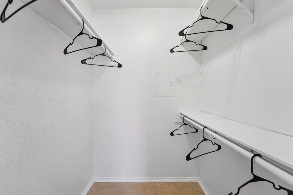 A white closet with black hangers.