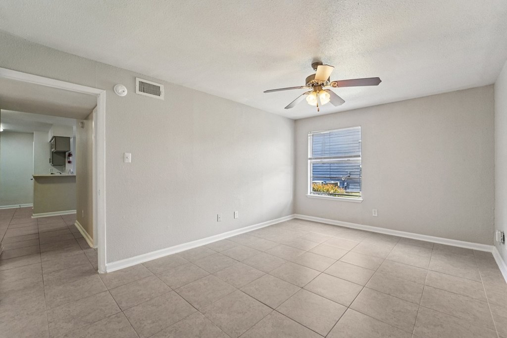 A room with a ceiling fan and a window with blinds.
