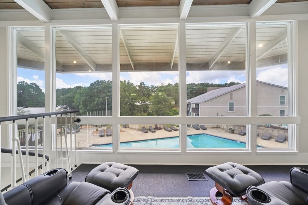A sunroom with a pool and a view of the backyard.at Hills at Hoover Apartments, Alabama, 35216