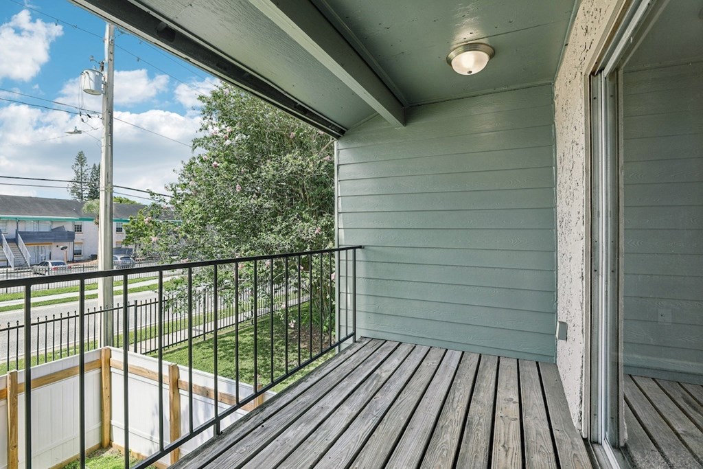 A balcony with a wooden floor and a metal railing.