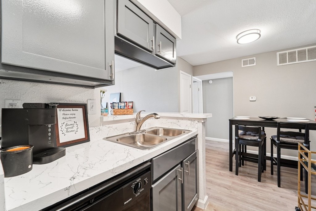 A kitchen with a white counter top and black cabinets.