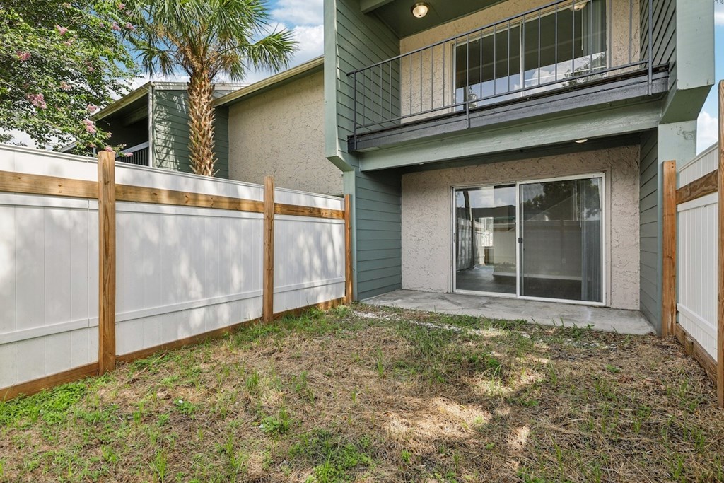 A house with a green exterior and a white fence.