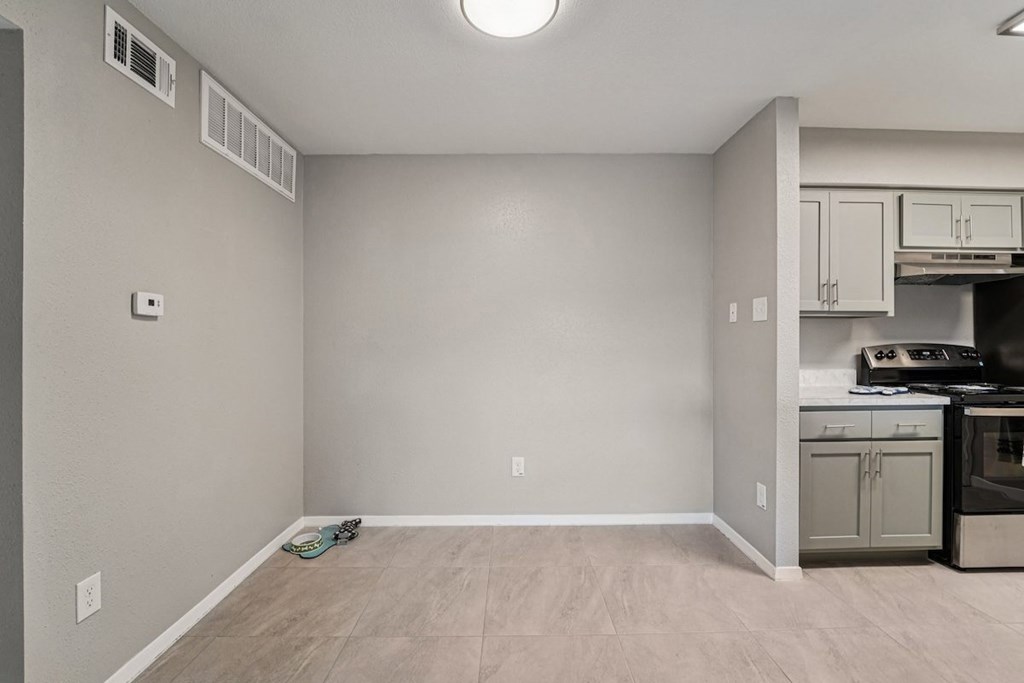 A kitchen area with a stove top oven and cabinets.