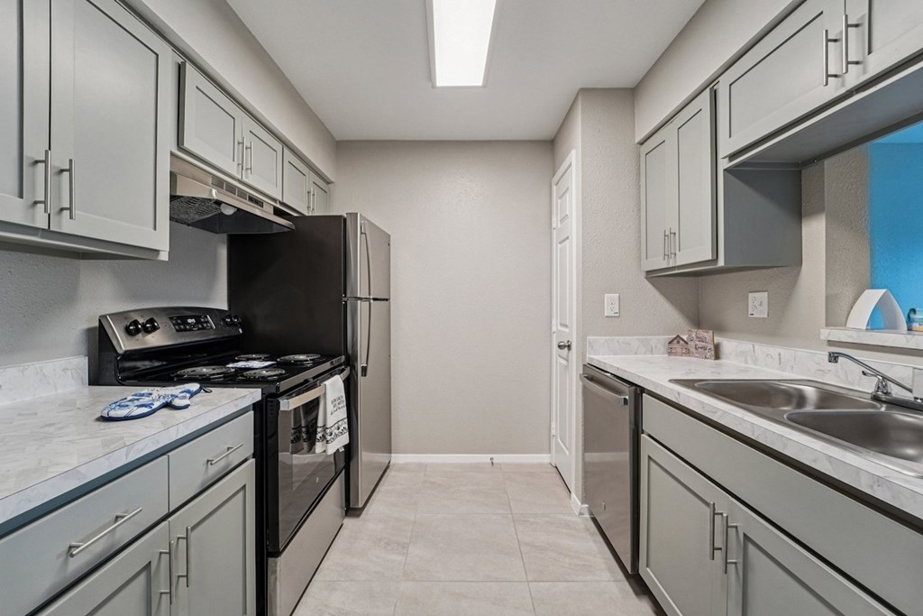 A kitchen with a black stove top oven and a black refrigerator.