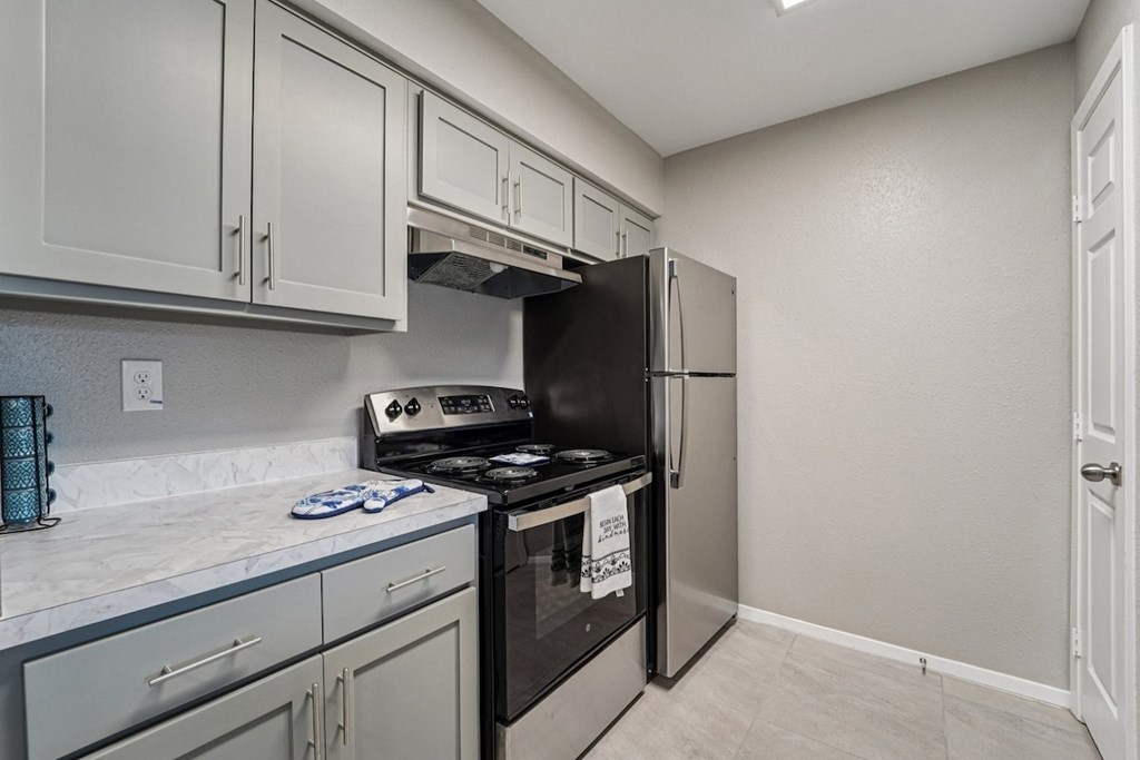 A kitchen with a black refrigerator and stove.