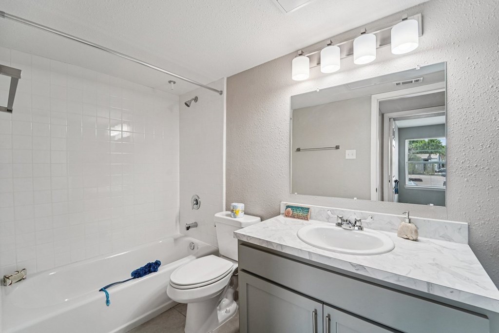 A white bathroom with a toilet, sink, and bathtub.
