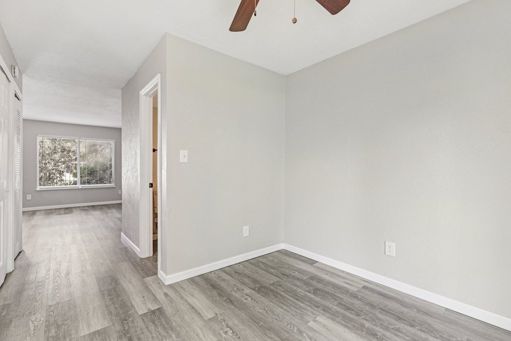 A room with a wooden floor and a ceiling fan.