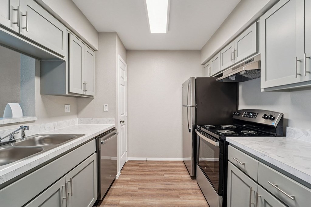 A kitchen with a black stove top oven and a white counter top.