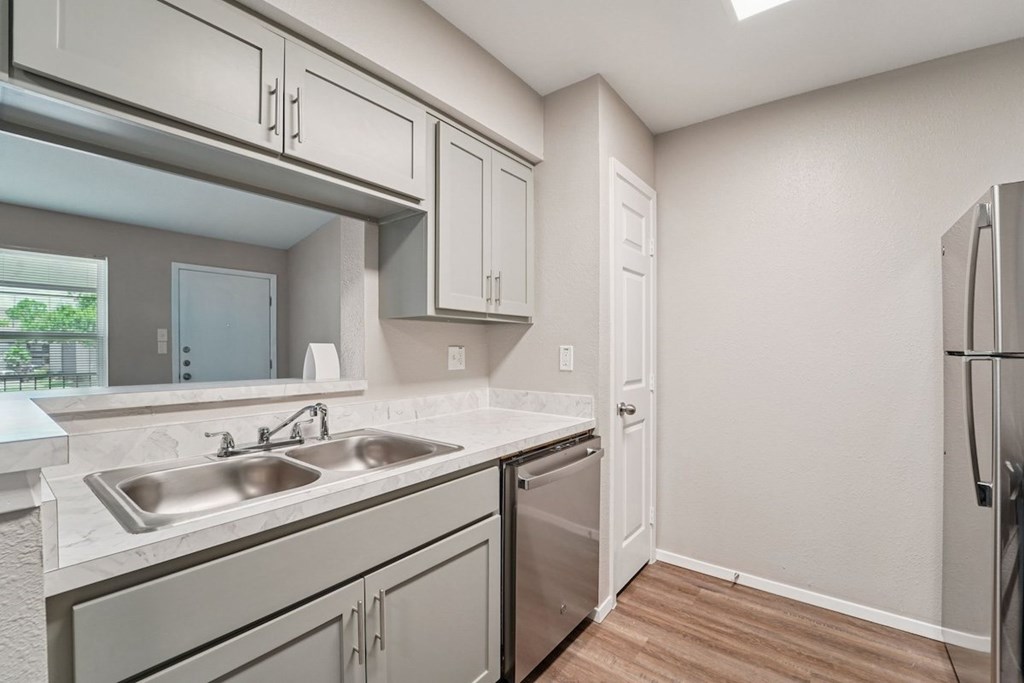 A kitchen with a sink, stove, and refrigerator.