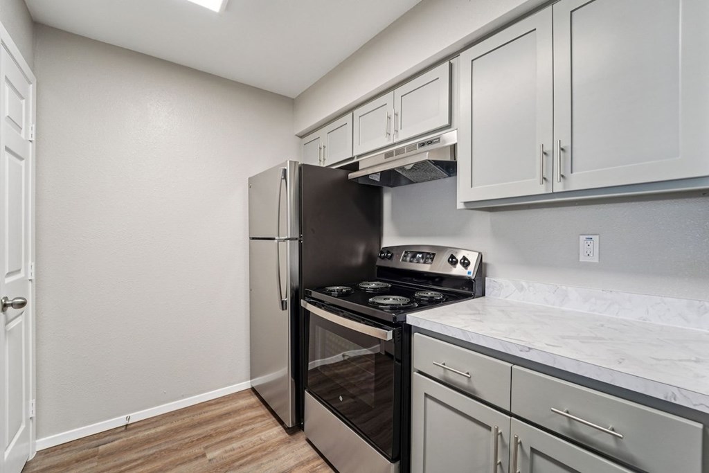 A kitchen with a stove top oven and a refrigerator.