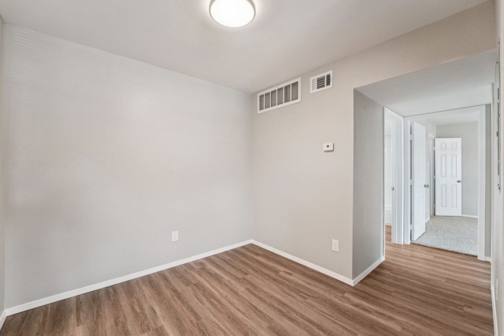 A room with a light on the ceiling and two air conditioning units on the wall.