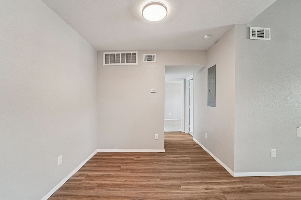 A room with a light on the ceiling and a door on the right.