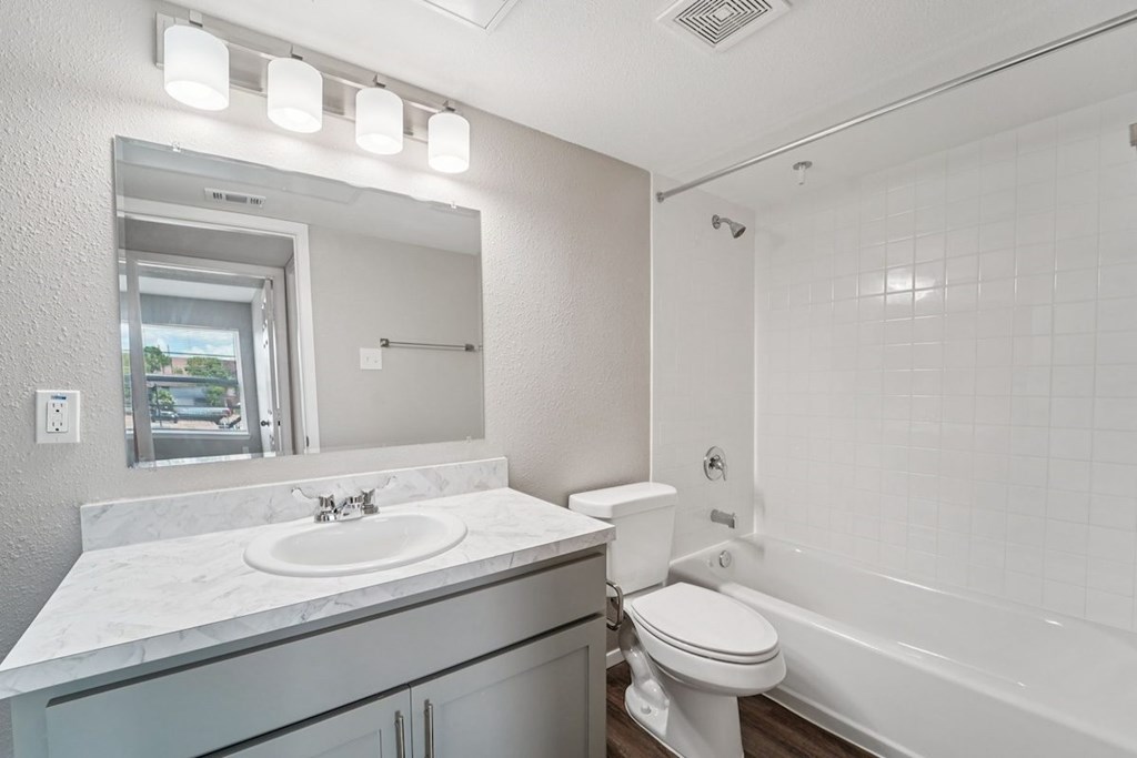 A white bathroom with a sink, toilet, and bathtub.