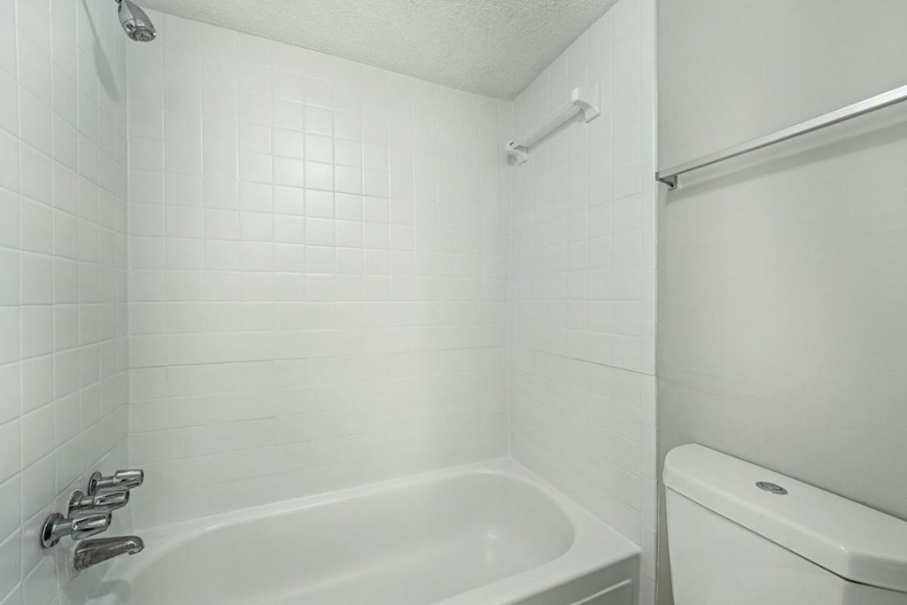 A white bathroom with a tub and toilet.at Hills at Hoover Apartments, Hoover, 35216
