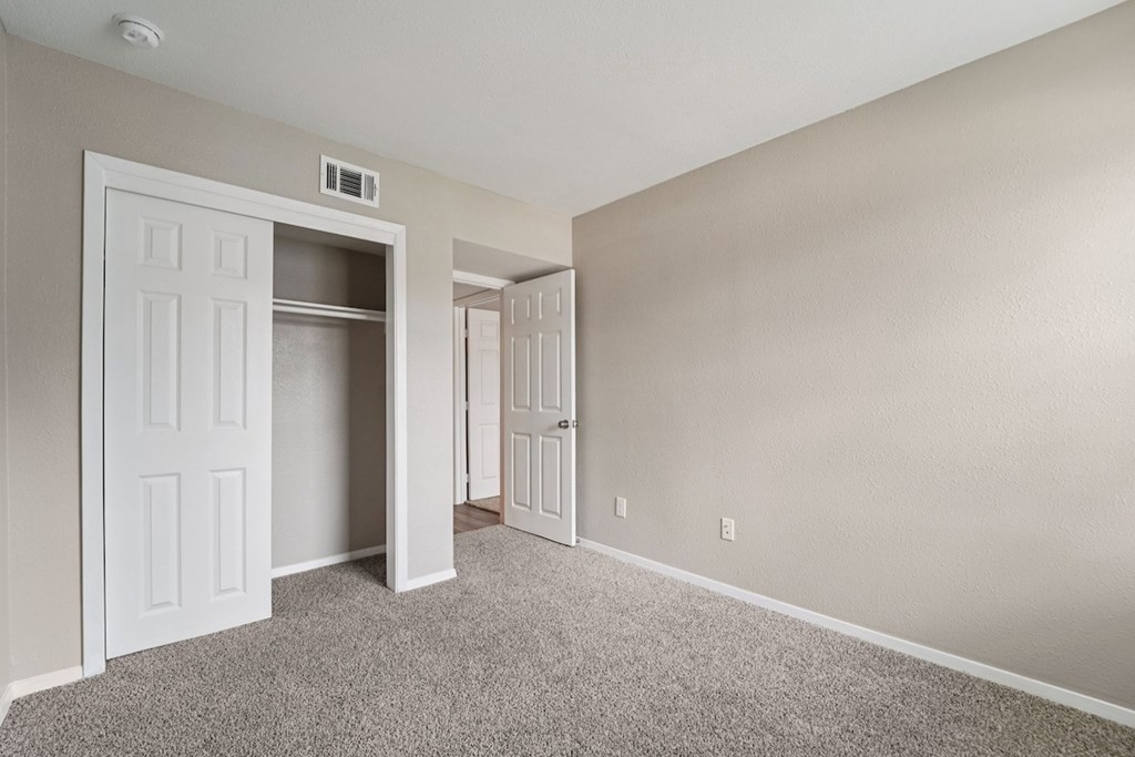 A room with a carpeted floor and a white door.