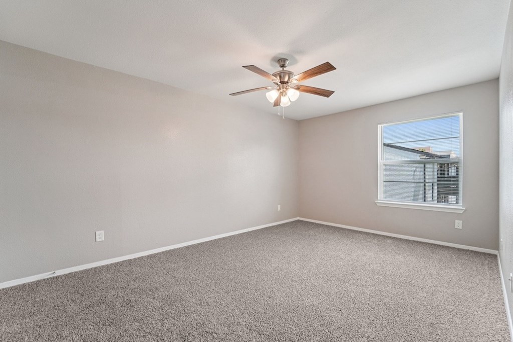 A room with a ceiling fan and a window.