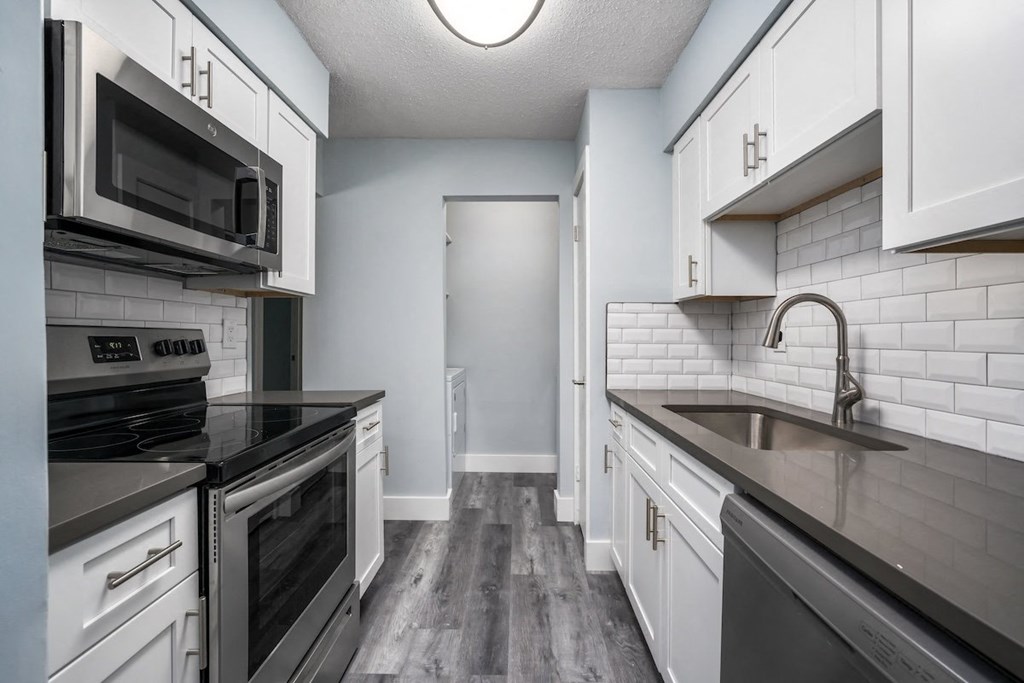 an empty kitchen with white cabinets and black appliances at Ascot Place Apartments, Birmingham, 35235