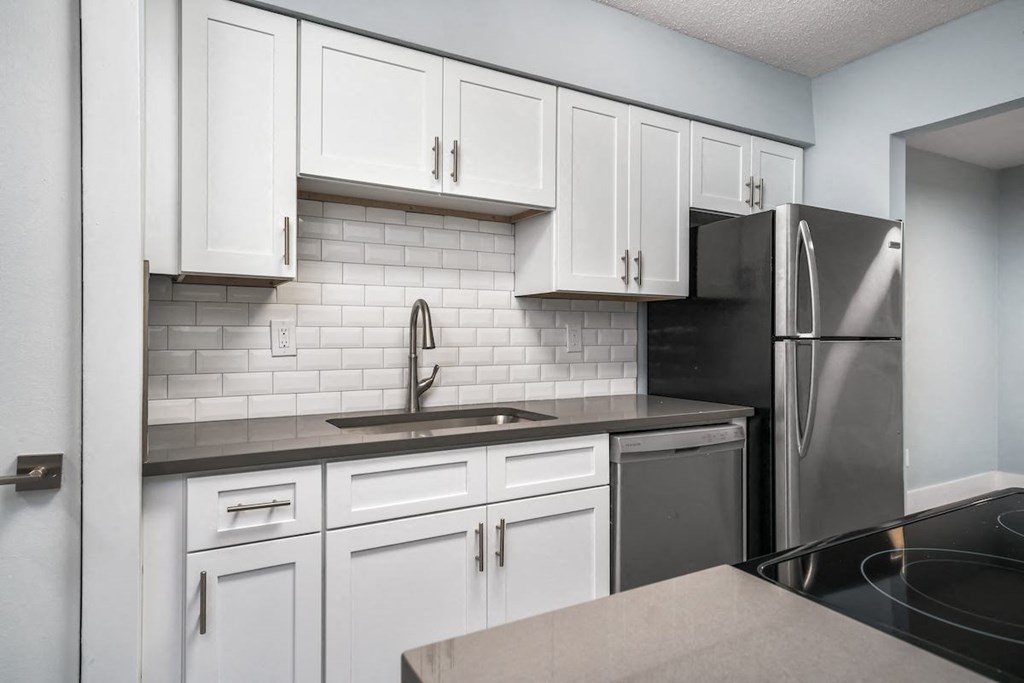 a kitchen with white cabinets and a stainless steel refrigerator at Ascot Place Apartments, Birmingham, 35235
