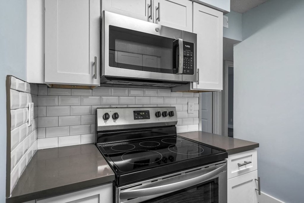 a kitchen with a stove and a microwave at Ascot Place Apartments, Birmingham, AL