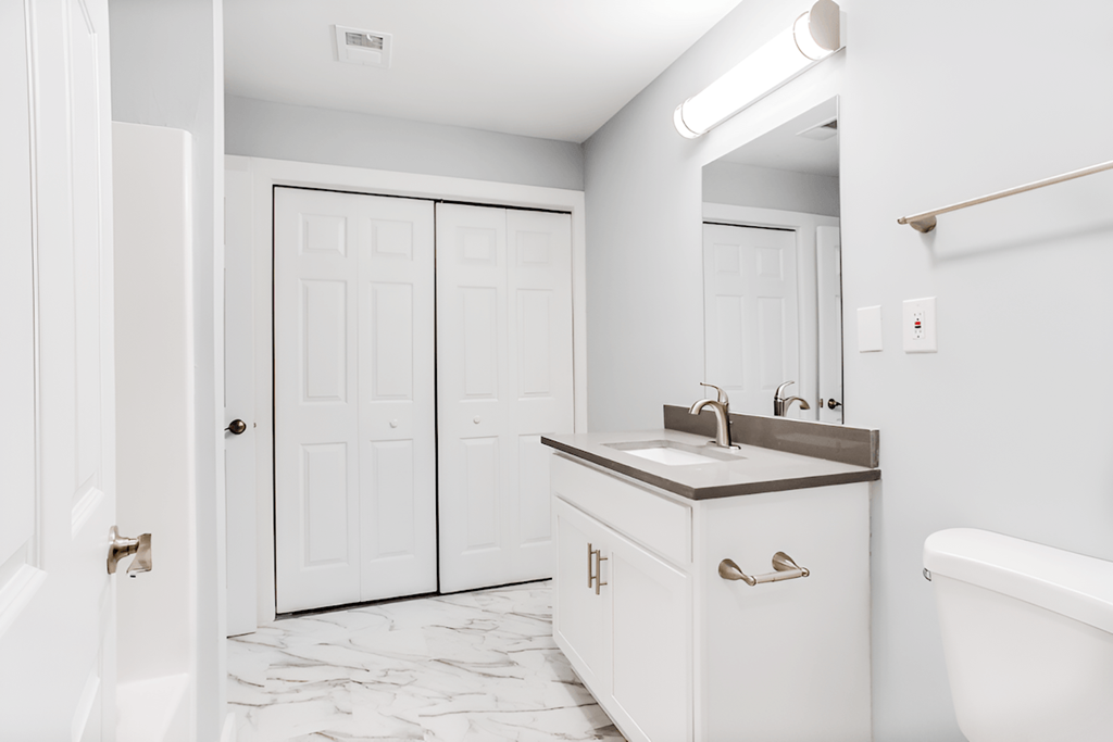 a bathroom with white cabinets and a sink and a mirror a bathroom with white cabinets and a sink and a mirror at Ascot Place Apartments, Birmingham, 35235