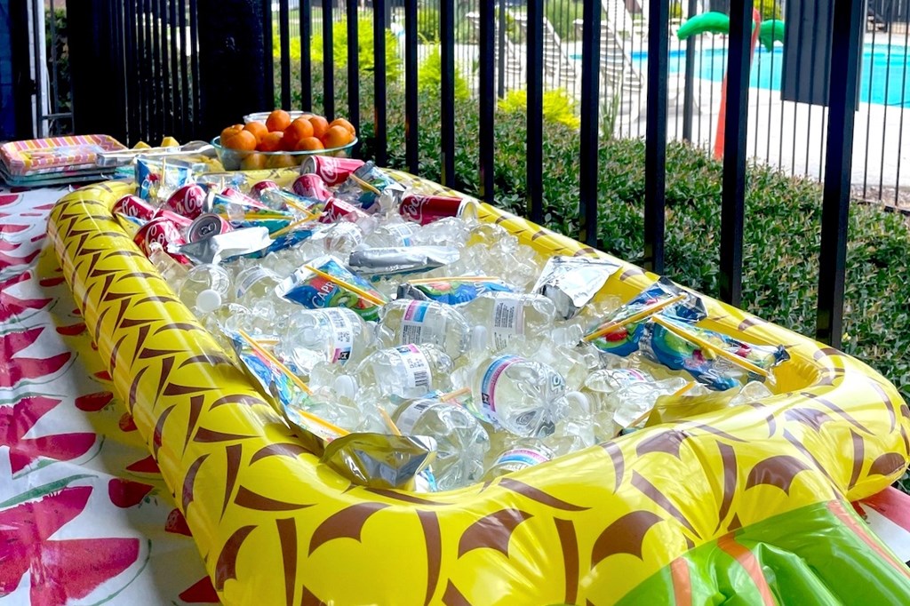A table covered with a yellow tablecloth and filled with plastic bottles.