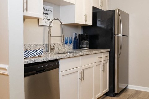 a kitchen with white cabinets and a stainless steel refrigerator