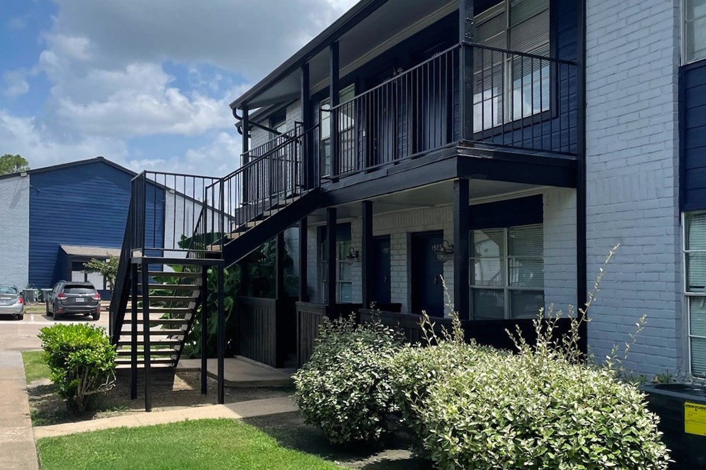 A modern house with a balcony and stairs leading to the second floor.