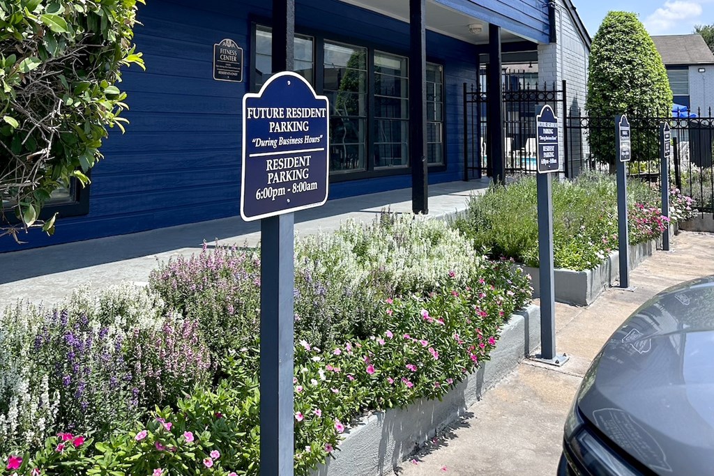 A sign for future resident parking is displayed in front of a building.