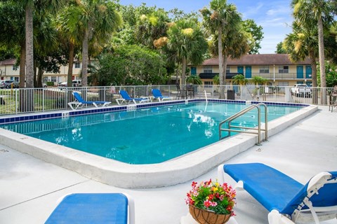 One of Ridge Apartments two sparkling swimming pools with a sundeck and lounge chairs