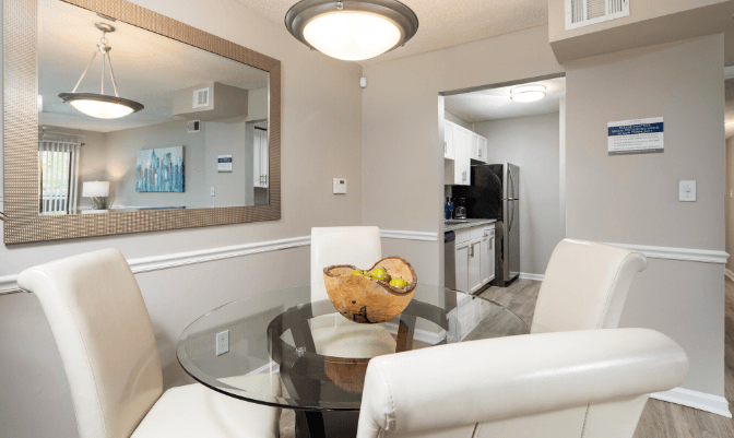 a dining room with a glass table and white chairs at Crestwood Green, LLC, Birmingham Alabama