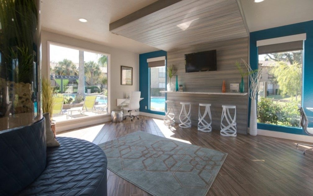a living room with a bar and a view of a pool