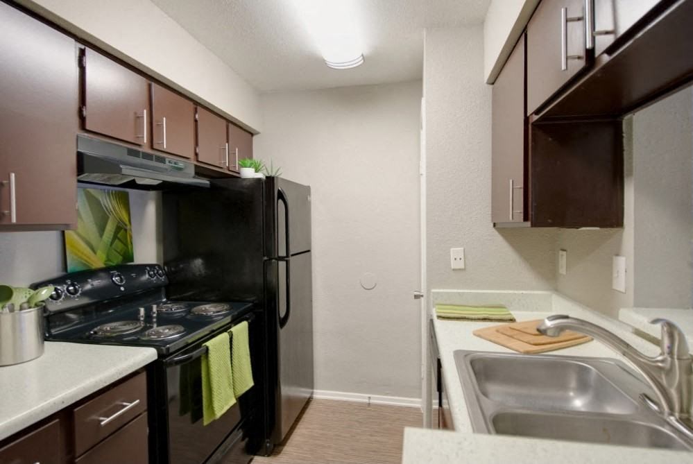 a kitchen with a stove refrigerator and sink