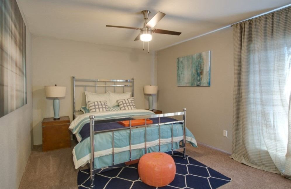 a bedroom with a bed and a ceiling fan
