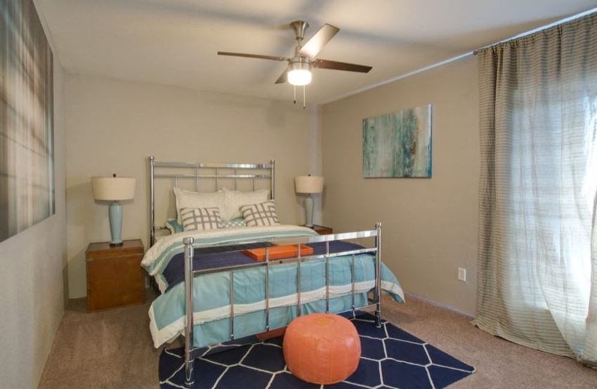 a bedroom with a bed and a ceiling fan