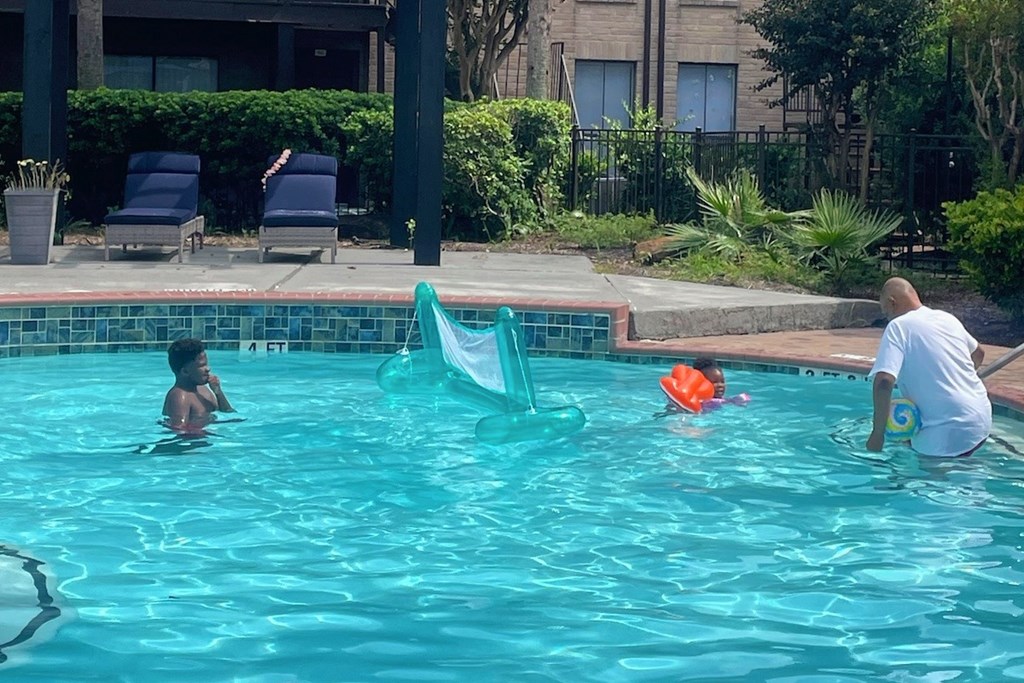 A man and a child are playing in a pool.