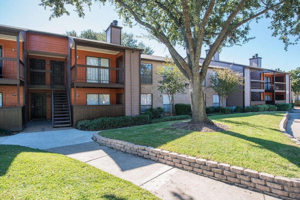 a residential building and lush landscaping at Hudson at Westchase Apartments in Houston