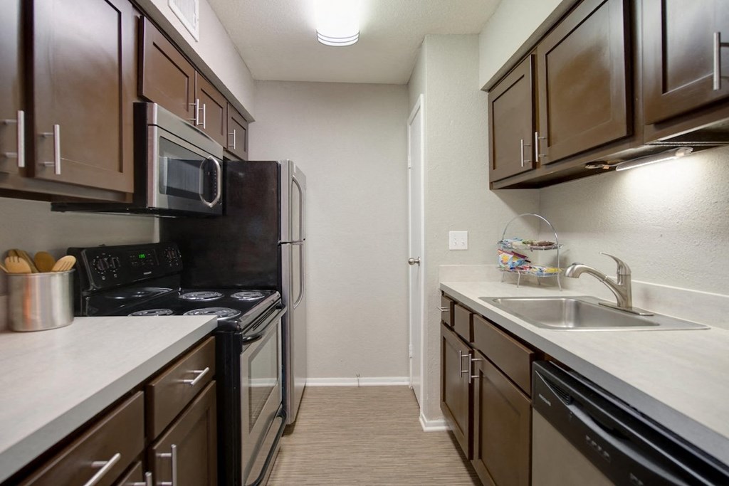 a kitchen with stainless steel appliances, built-in microwave, and wood cabinets at Hudson at Westchase