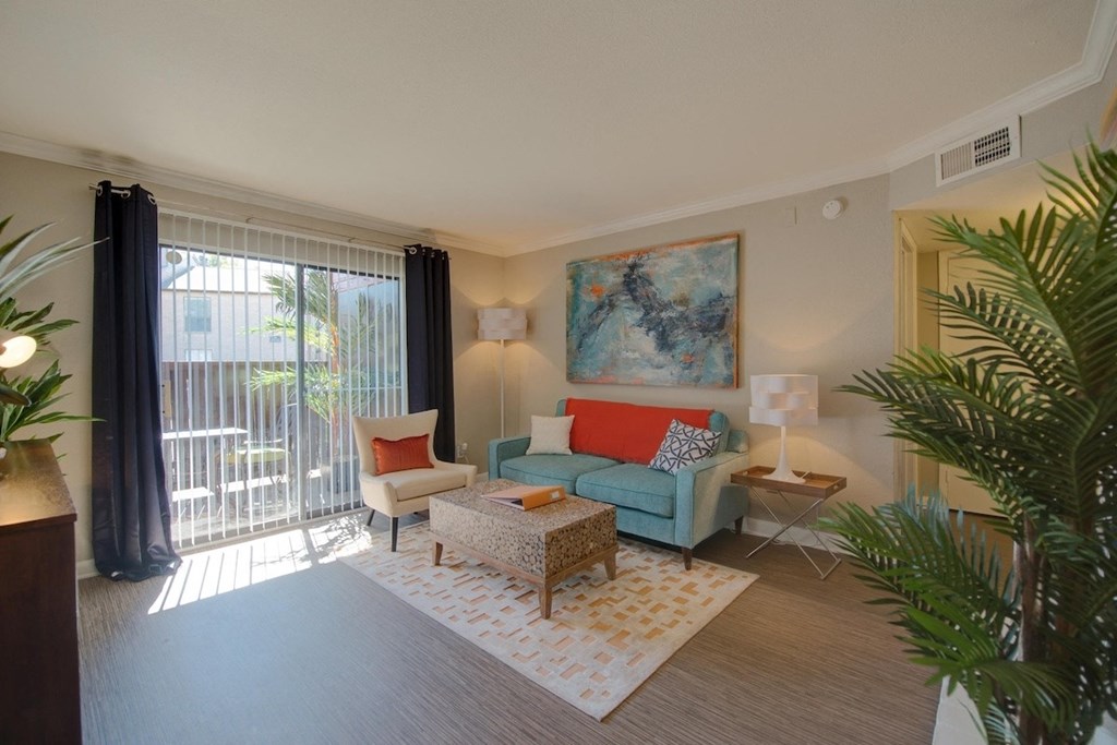 a living room with model furnishings, natural light, and wood-style floors at Hudson at Westchase