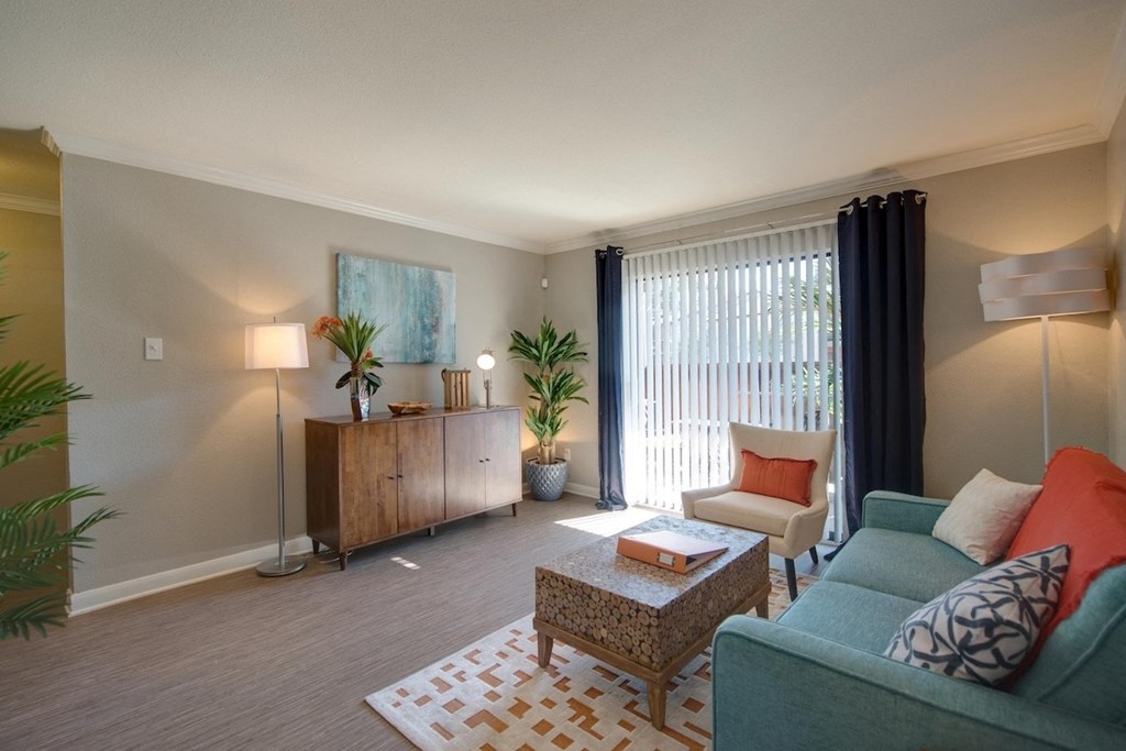 a spacious living room with modern features, model furnishings, and a sliding glass door