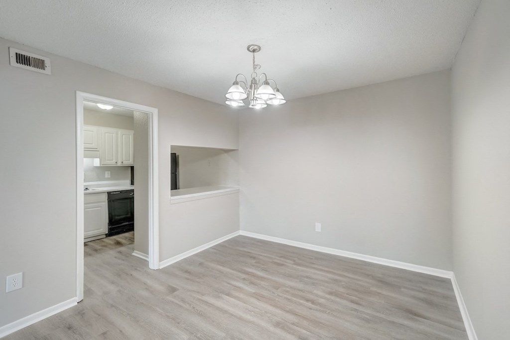 a dining room with wood-style flooring and modern chandelier at Hills at Hoover 35216