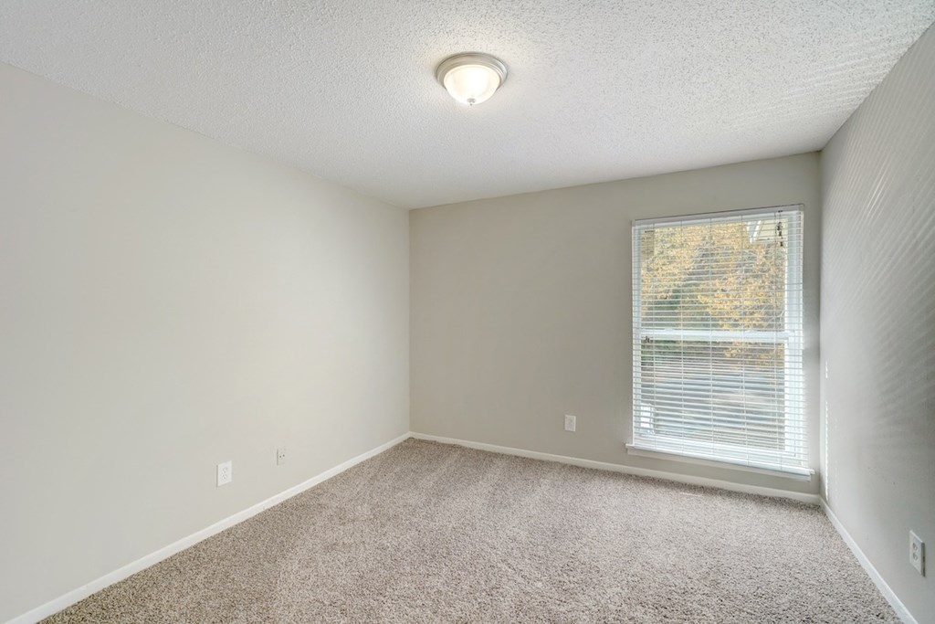a bedroom with carpet, light, and a large window at Hills at Hoover 35216