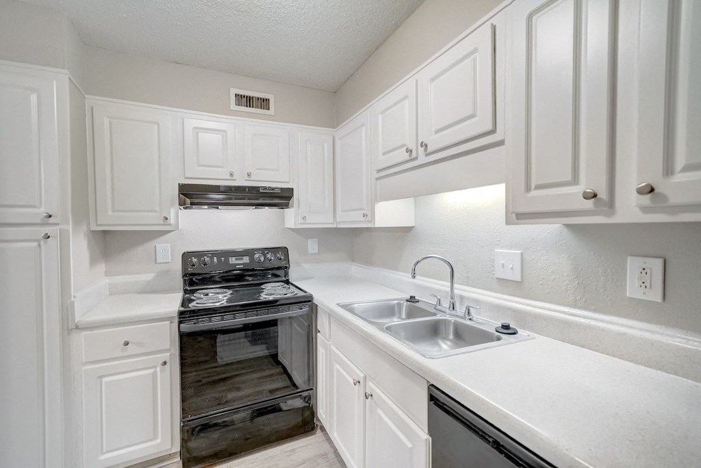 Hills-Hoover_Kitchen2 a kitchen with black appliances and white cabinets at Hills at Hoover 35216