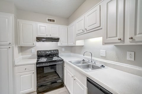 Hills-Hoover_Kitchen2 a kitchen with black appliances and white cabinets at Hills at Hoover 35216