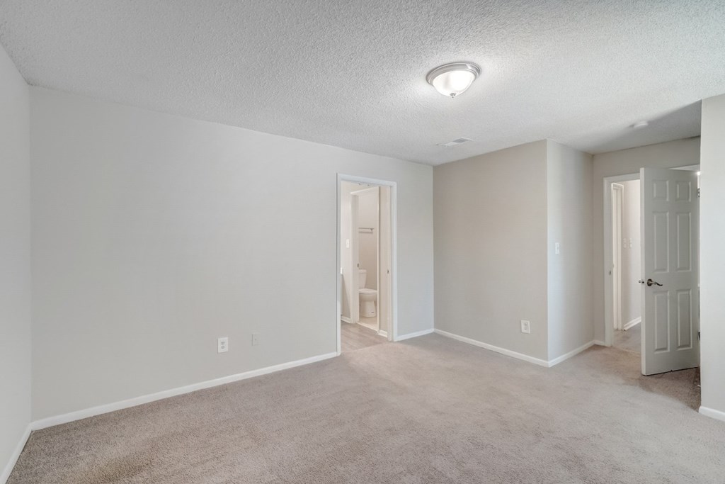 a spacious bedroom with bathroom access at Hills at Hoover 35216